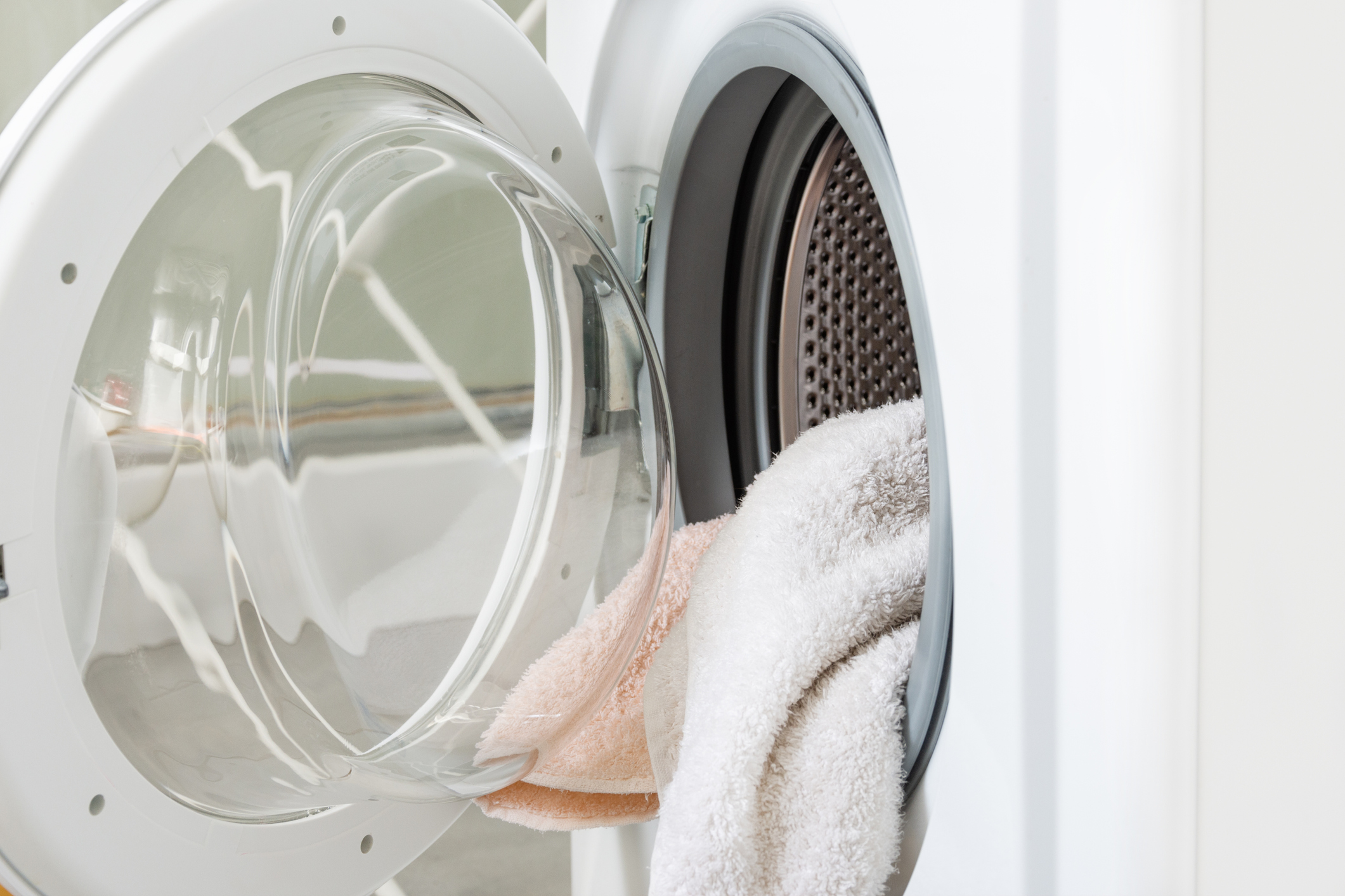 Washing machine with towels in a drum. Household.